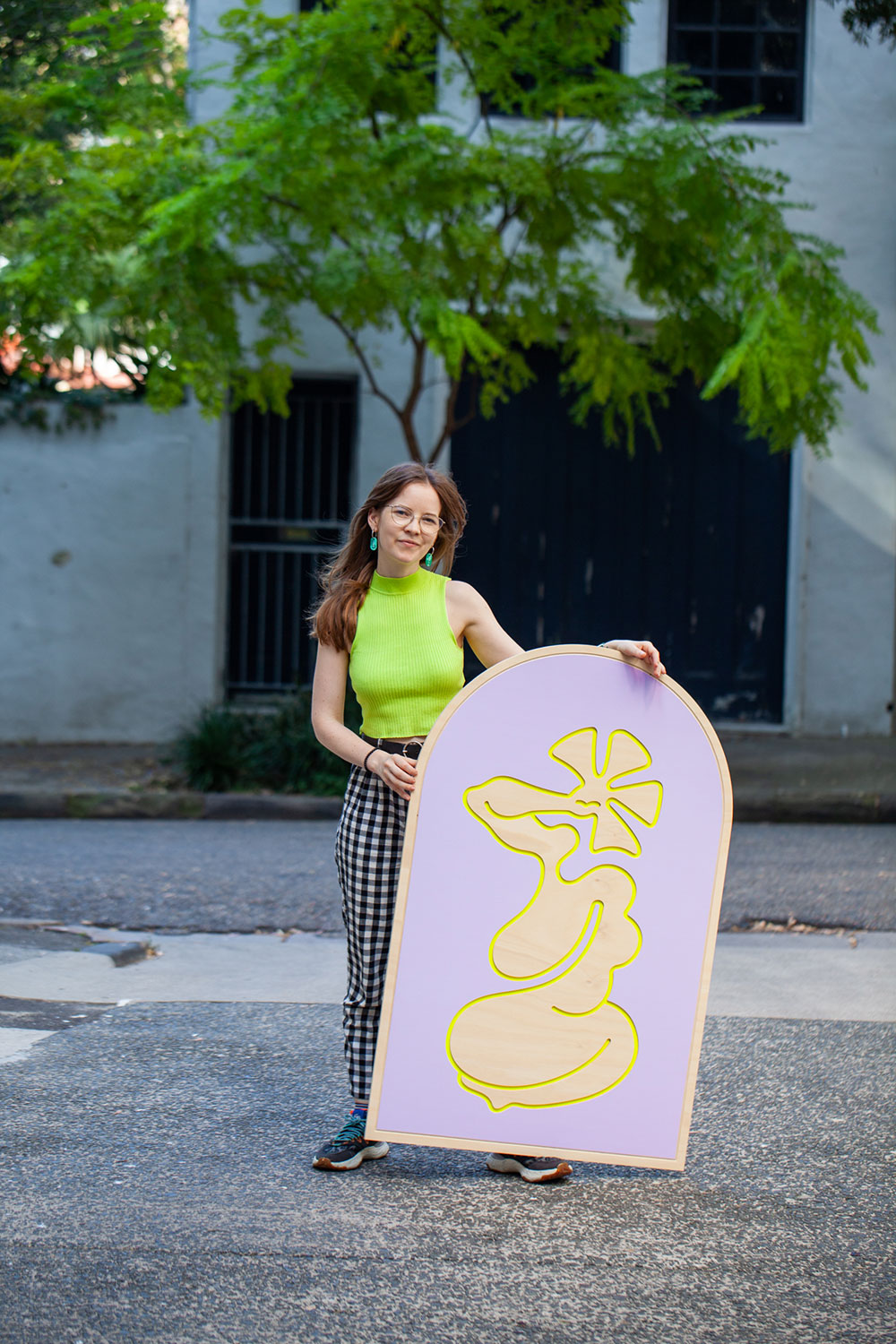 Missy with timber-cut artwork. The artwork is 1.2m tall, is arched and has a surrealist cut out of a human shape in purple and yellow.