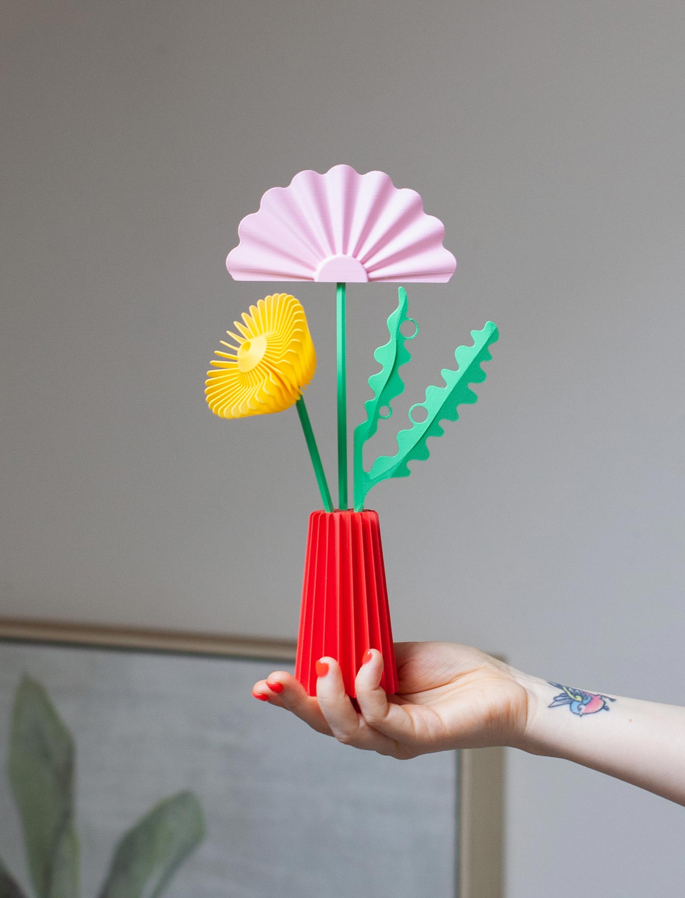 3D printed flower sculpture designed by Wow Mountain. Red base, green fronds, pink fan top and yellow rose flower